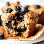 Moist blueberry protein muffin with golden brown crust, packed with fresh blueberries and a tender crumb